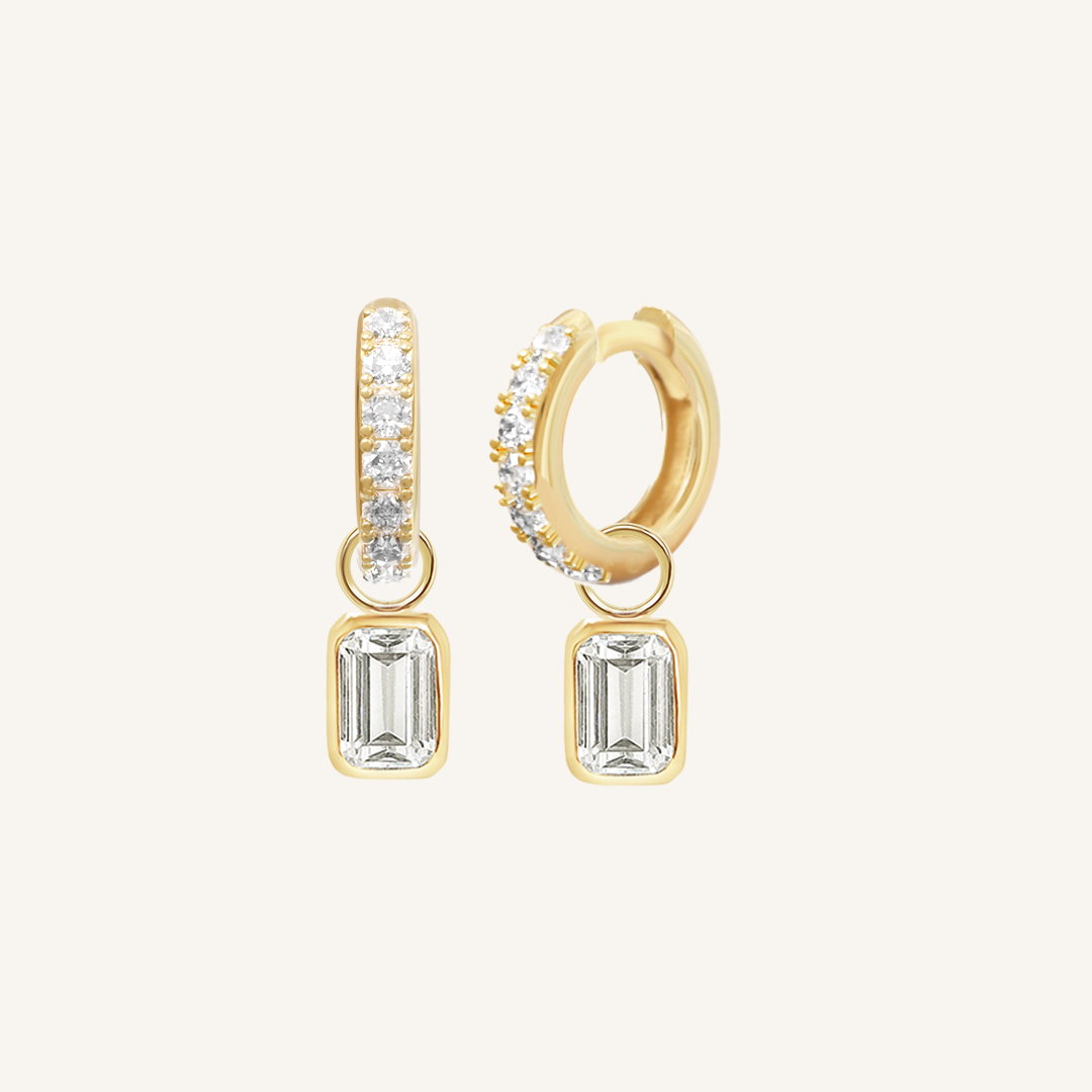 A pair of gold-tone radiant crystal hoop earrings with charm drops.