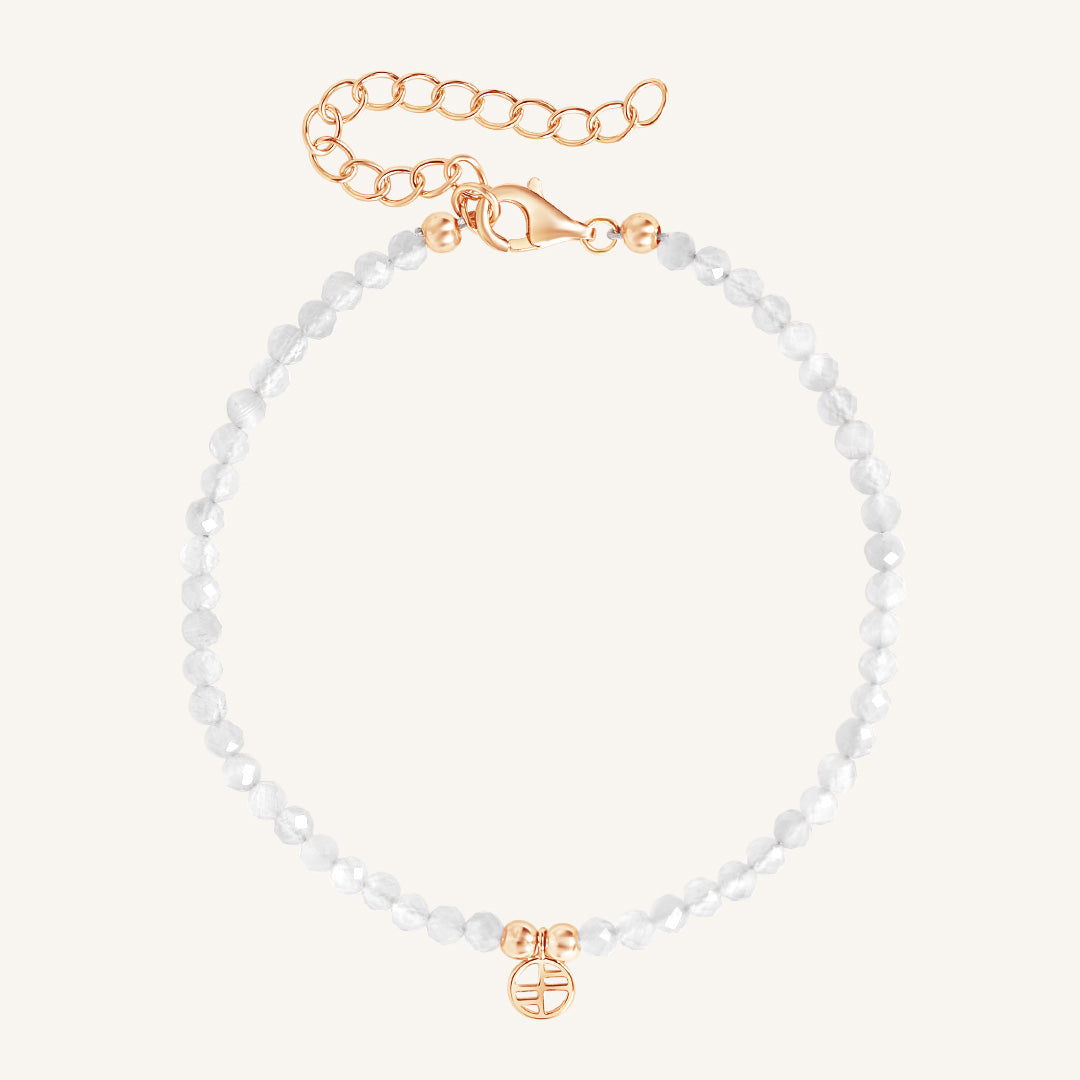 Bracelet with white beads and gold clasp on a white background