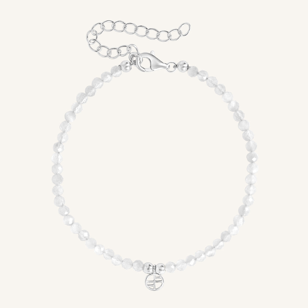 Silver bracelet with a small round charm on a white background