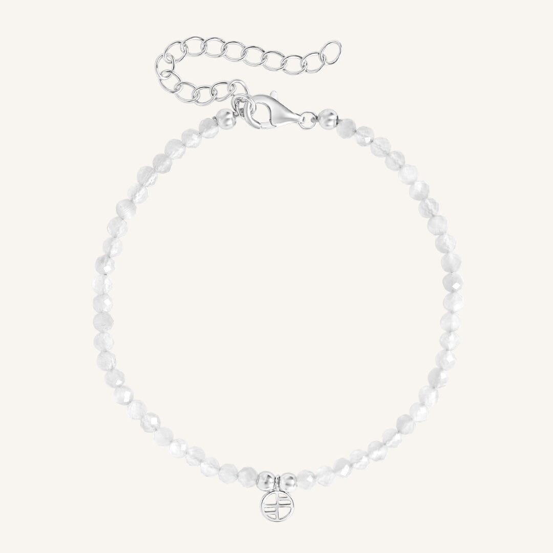 Silver bracelet with a small round charm on a white background