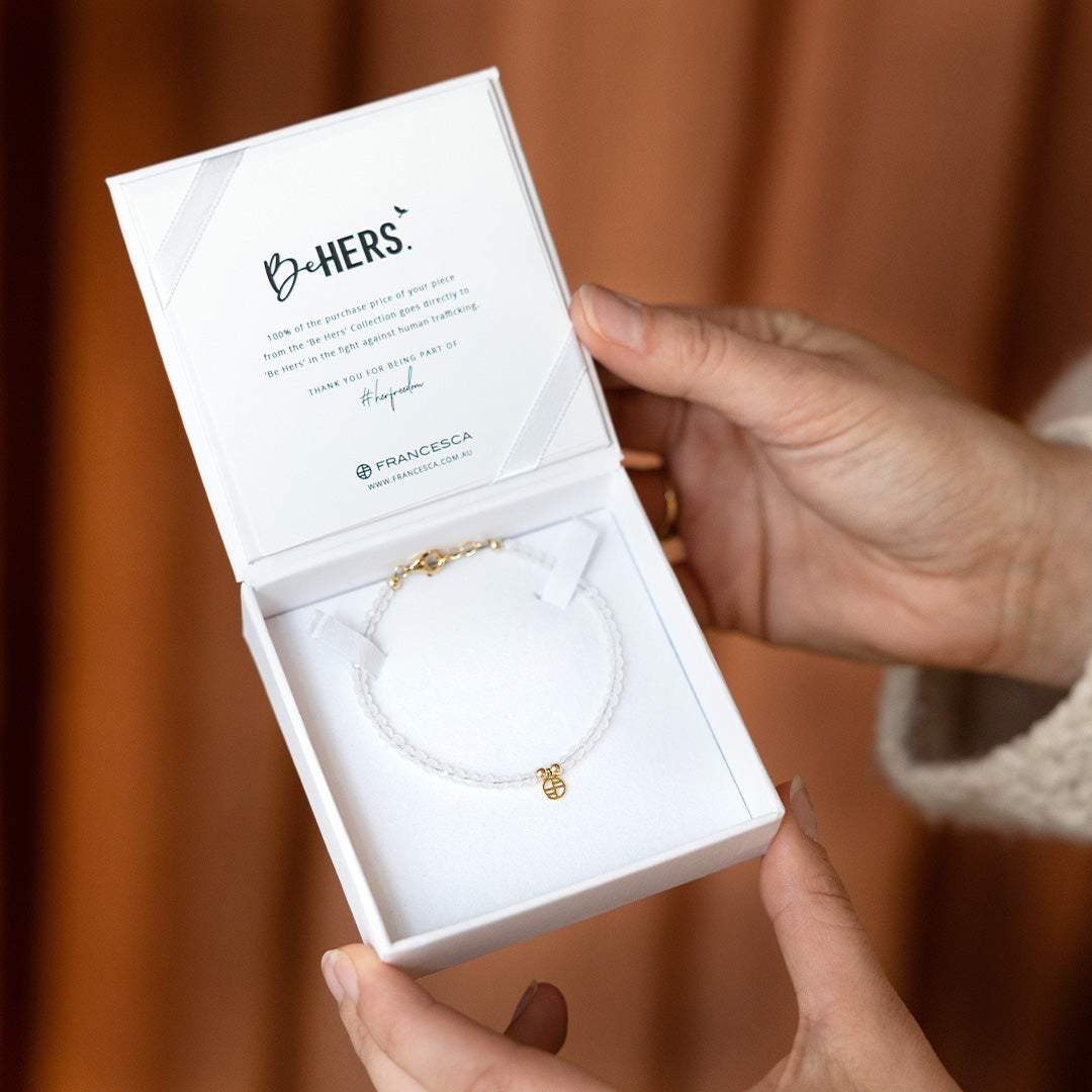 bracelet inside box held by a person against a brown background