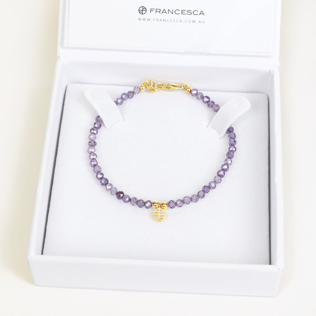 Purple beaded necklace with gold clasp in a white box labeled 'Francesca'.