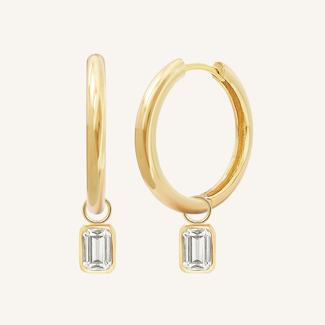 A pair of gold-colored hoop earrings with transparent crystal embellishments.