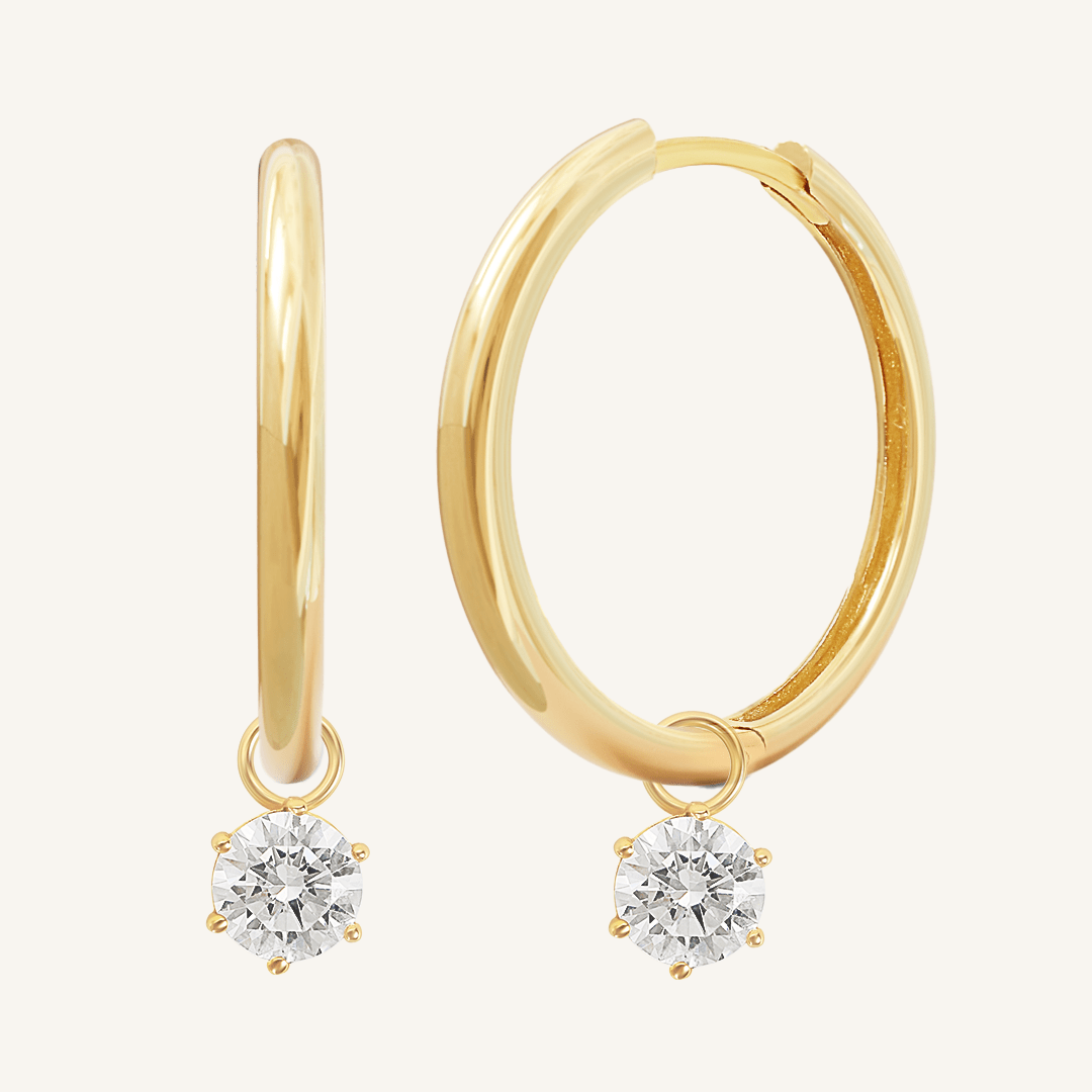 A pair of gold-tone charm hoop earrings with drop pendant design.
