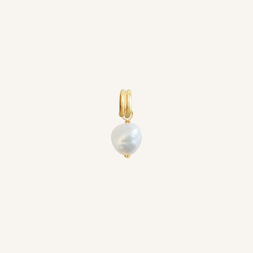 A petite pearl charm with gold findings
