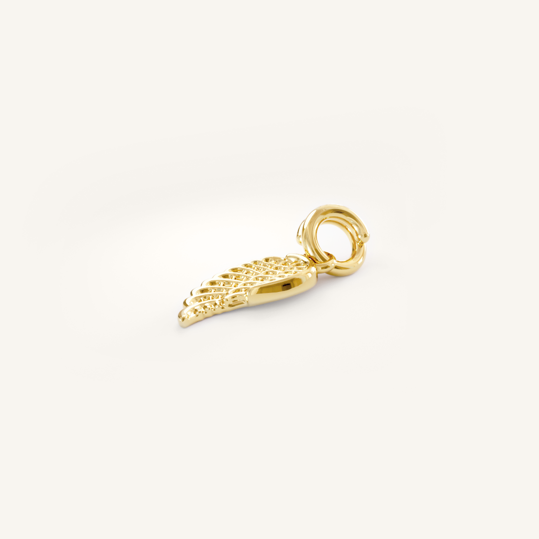 A gold-coloured angel wing charm with intricate details