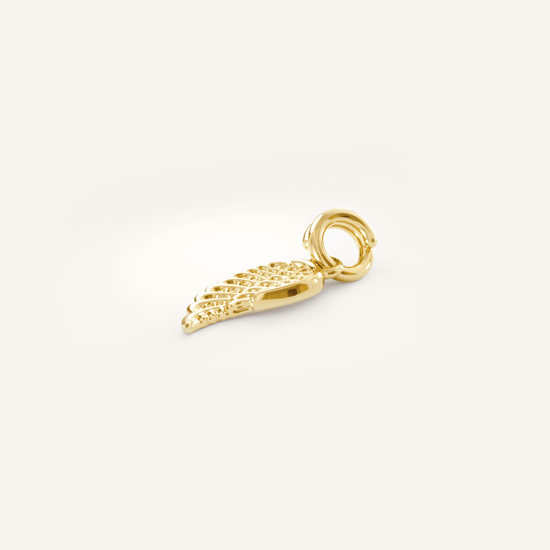 A gold-coloured angel wing charm with intricate details