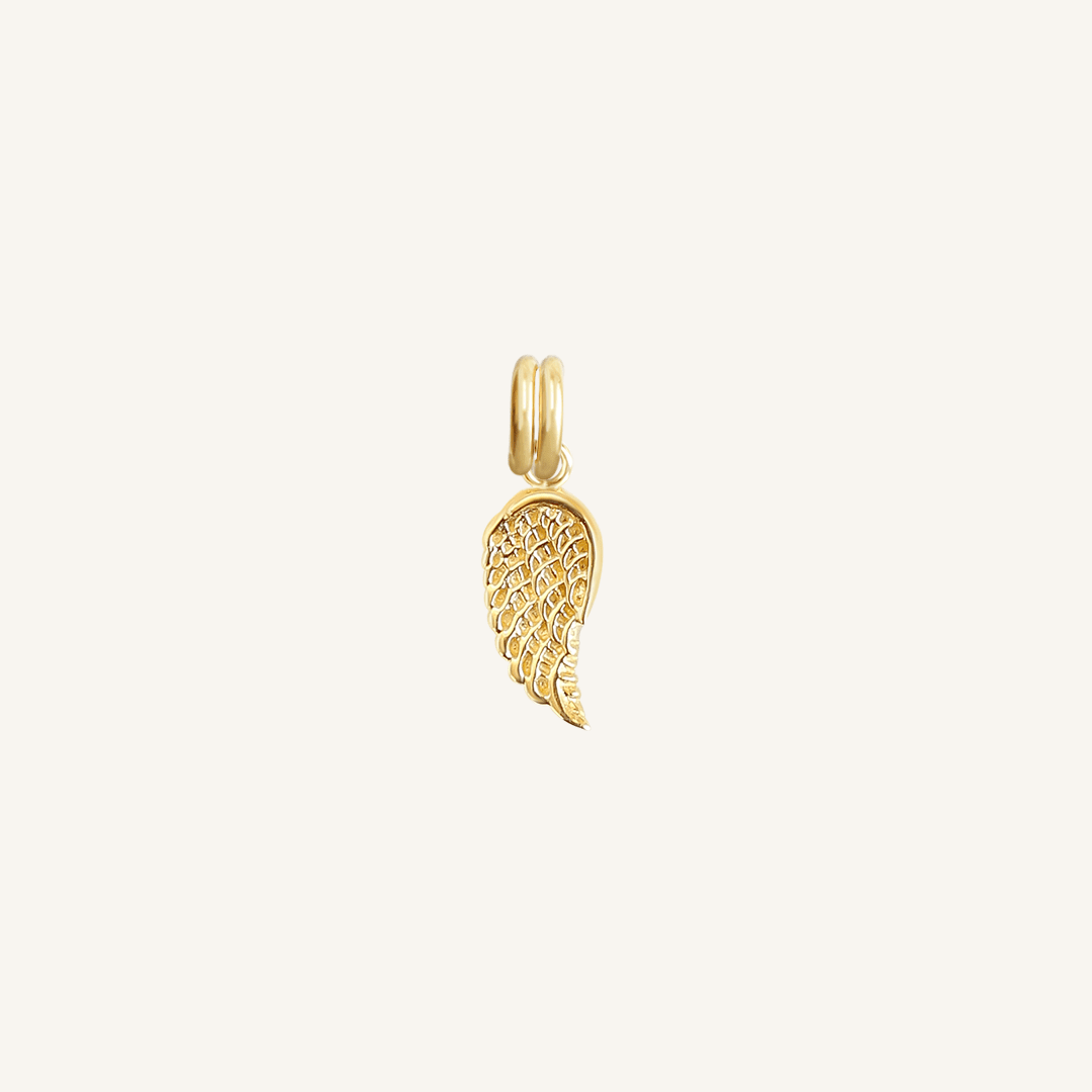 A gold-coloured angel wing charm with intricate details