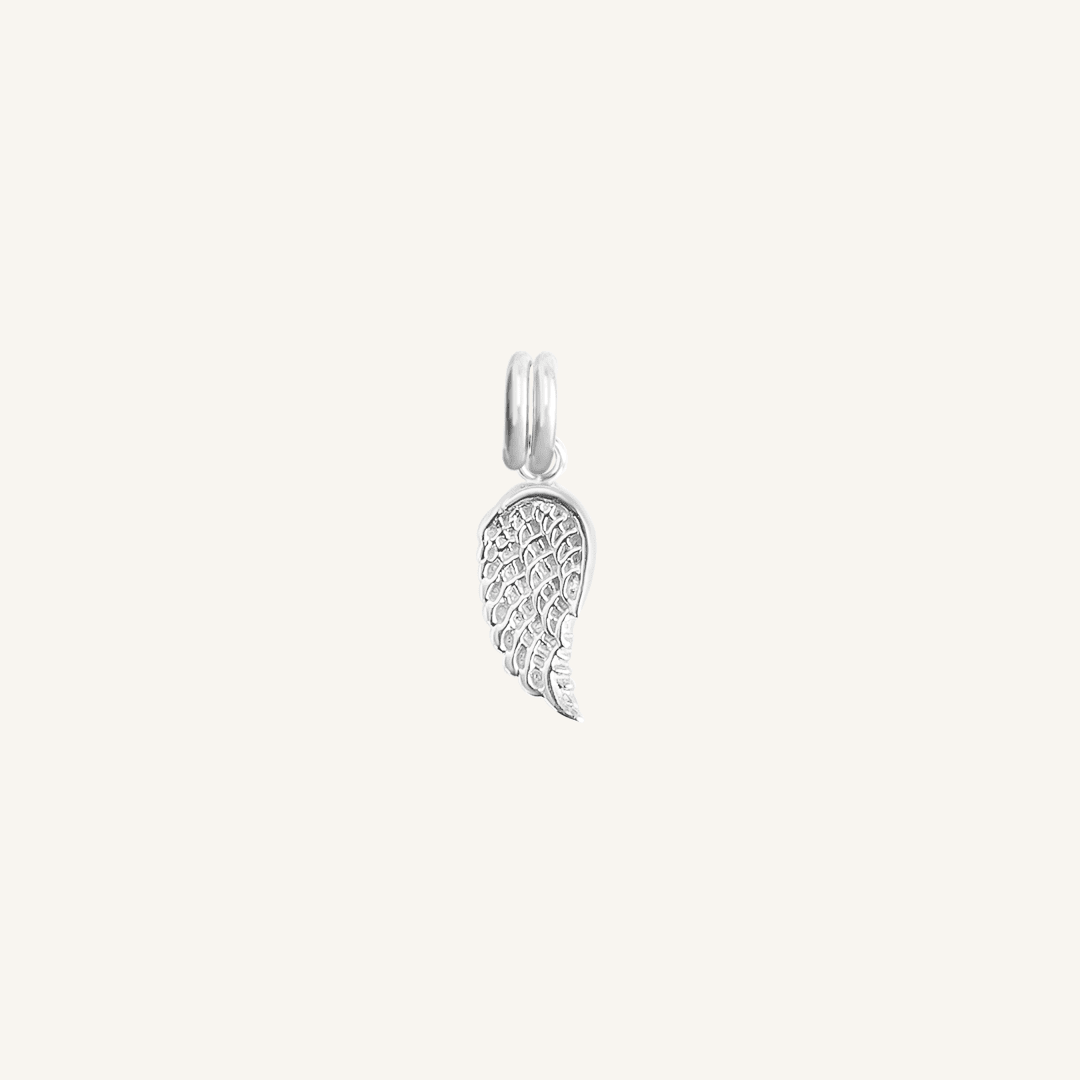 A silver-coloured angel wing charm with intricate details