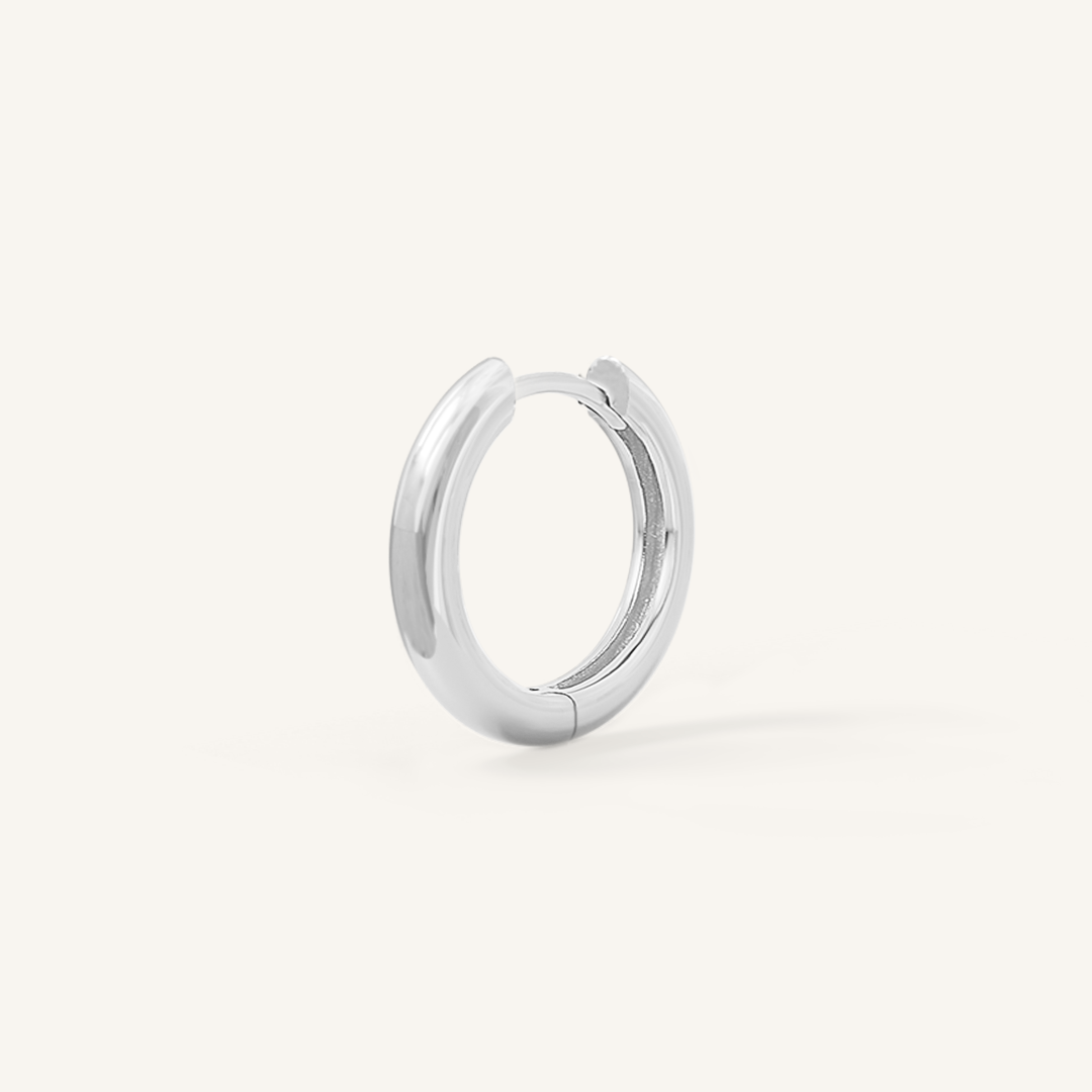A silver hoop earring on a white background