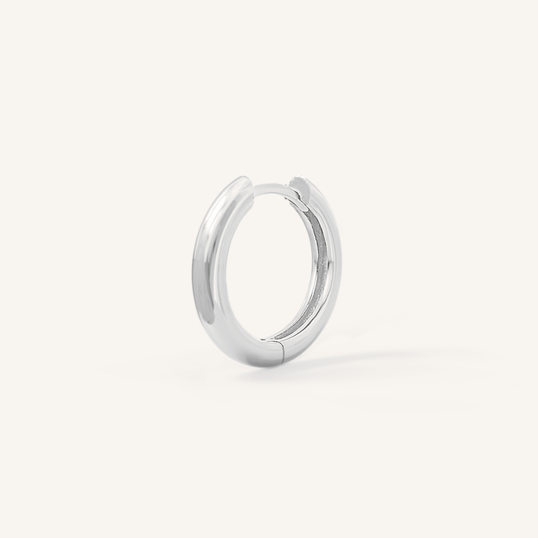A silver hoop earring on a white background