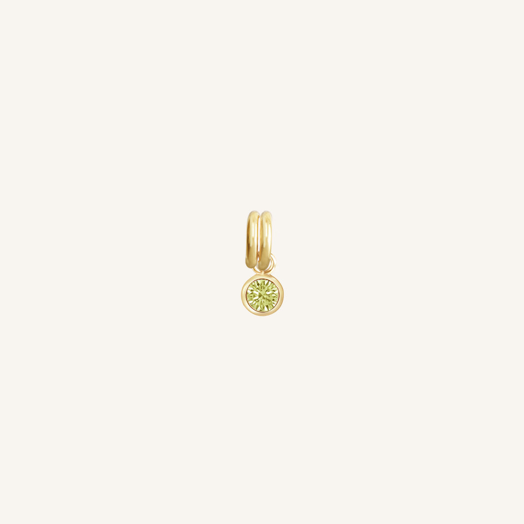 Gold round charm with bezel-set peridot green cubic zirconia representing the August birthstone