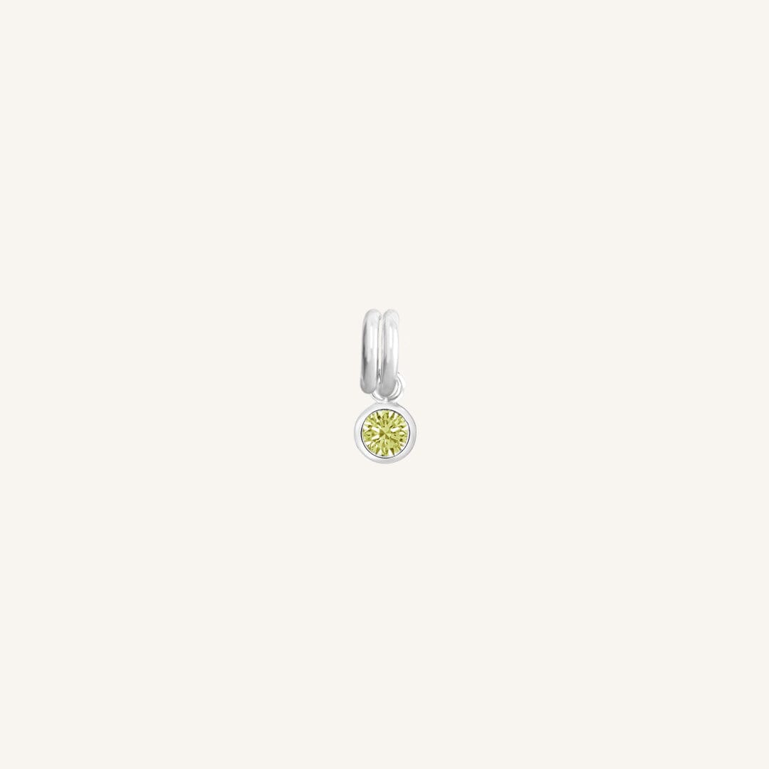 Silver round charm with bezel-set peridot green cubic zirconia representing the August birthstone