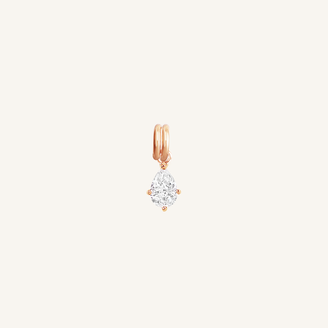 A teardrop-shaped cubic zirconia charm with a rose metal tone