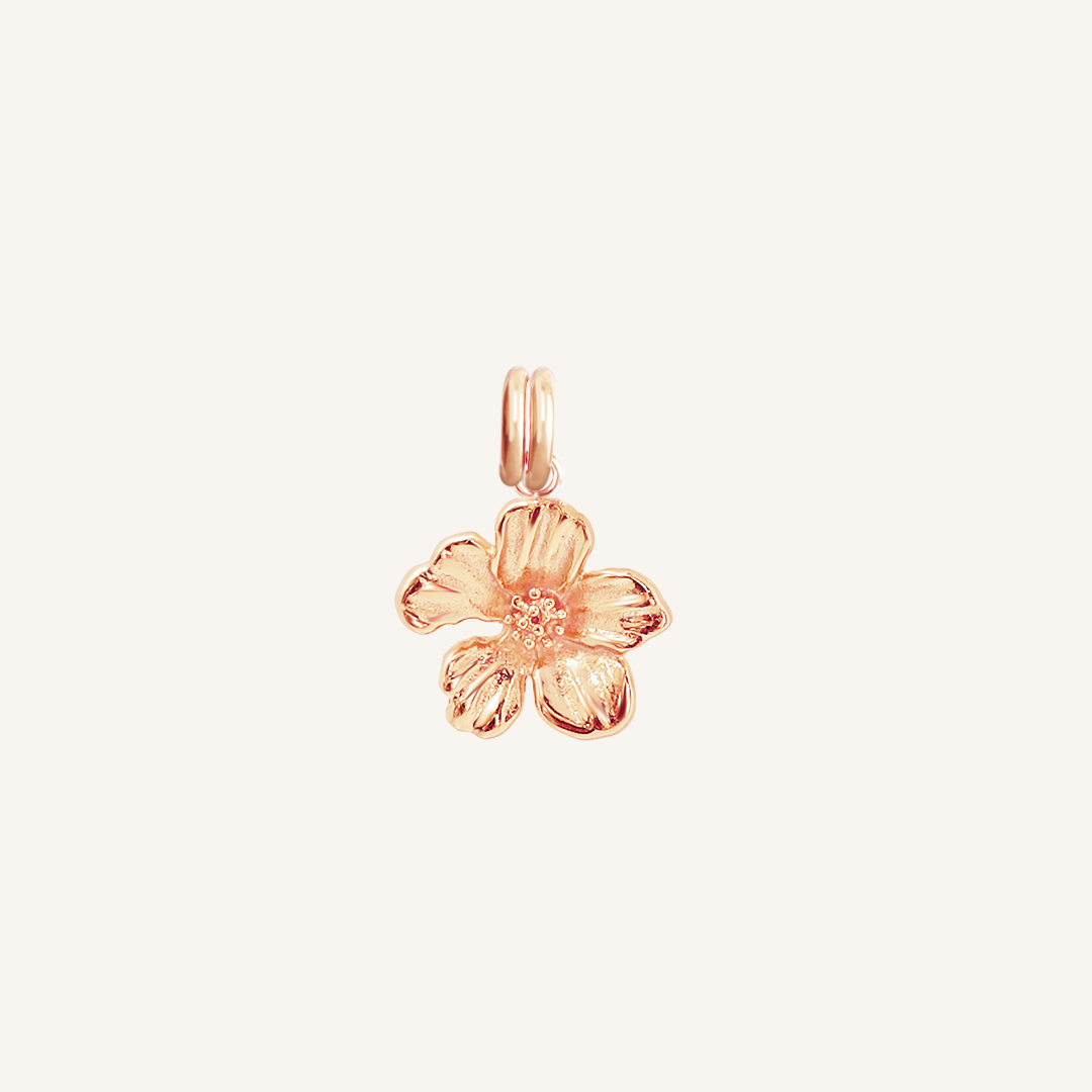 A rose-colored metal charm in the shape of an Azalea flower.