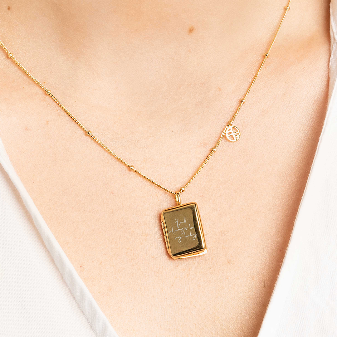 A gold locket with a laser engraved inscription of 'You'll always be my baby'. Attached to a chain and around the neck