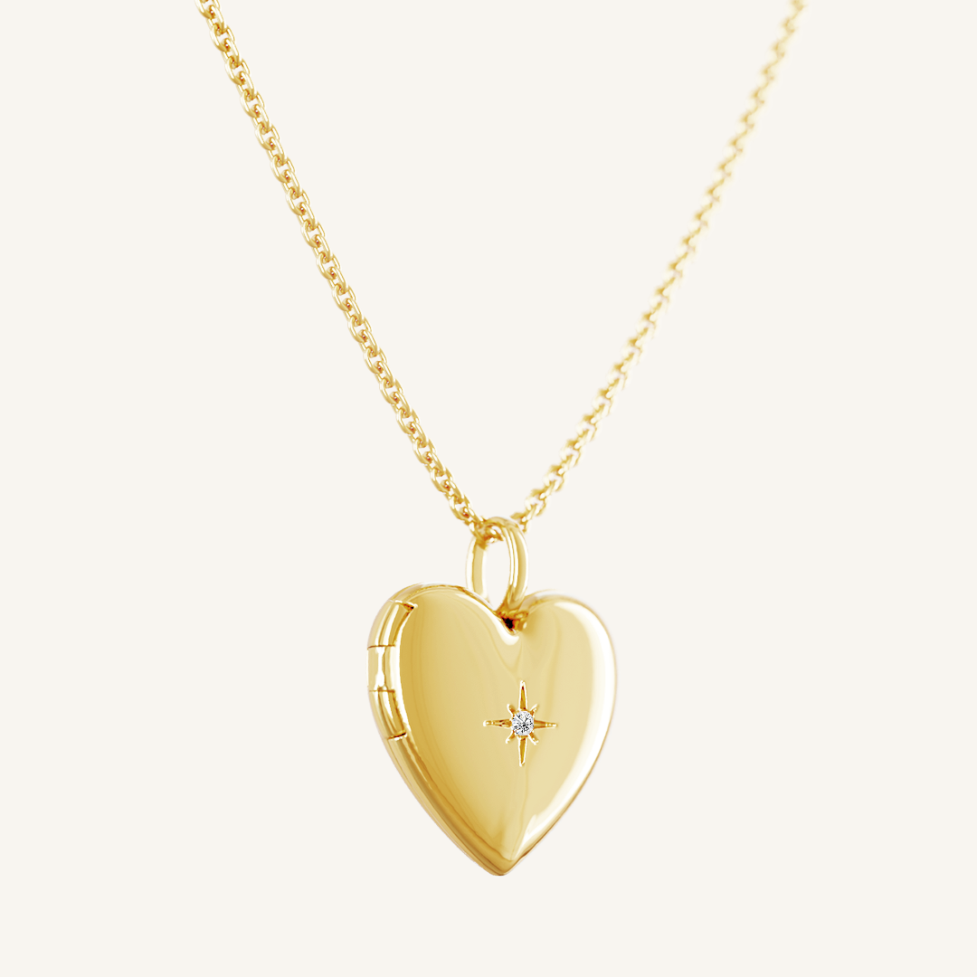 A gold heart-shaped photo locket closed on plain chain