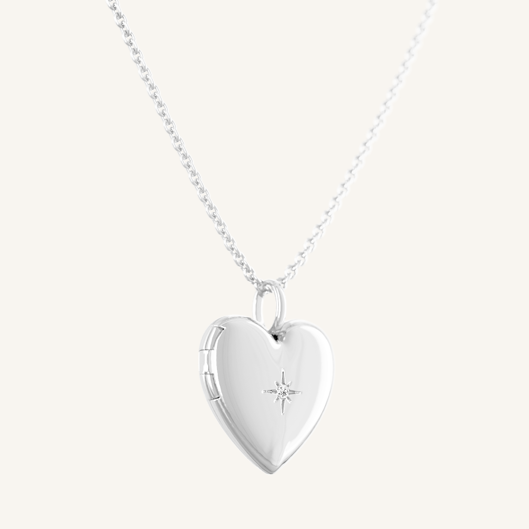 A silver heart-shaped photo locket closed on plain chain