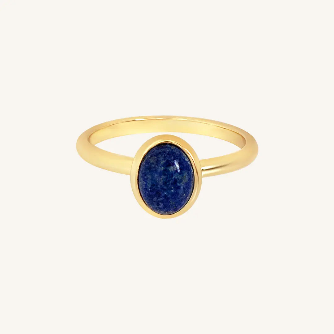 A gold ring with a deep-blue lapis stone set in a thinner band.