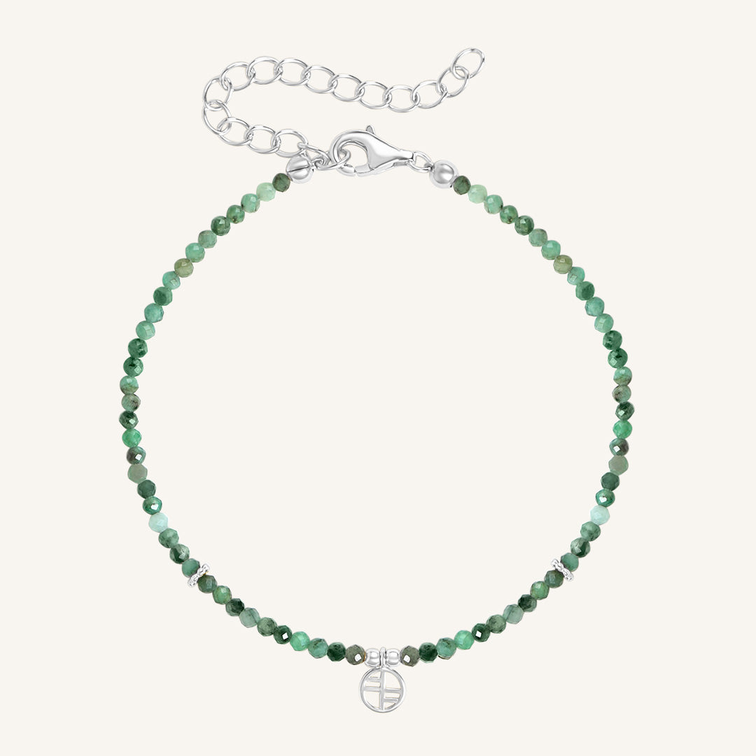 A beaded bracelet with green gemstones and a silver-tone clasp and charm.