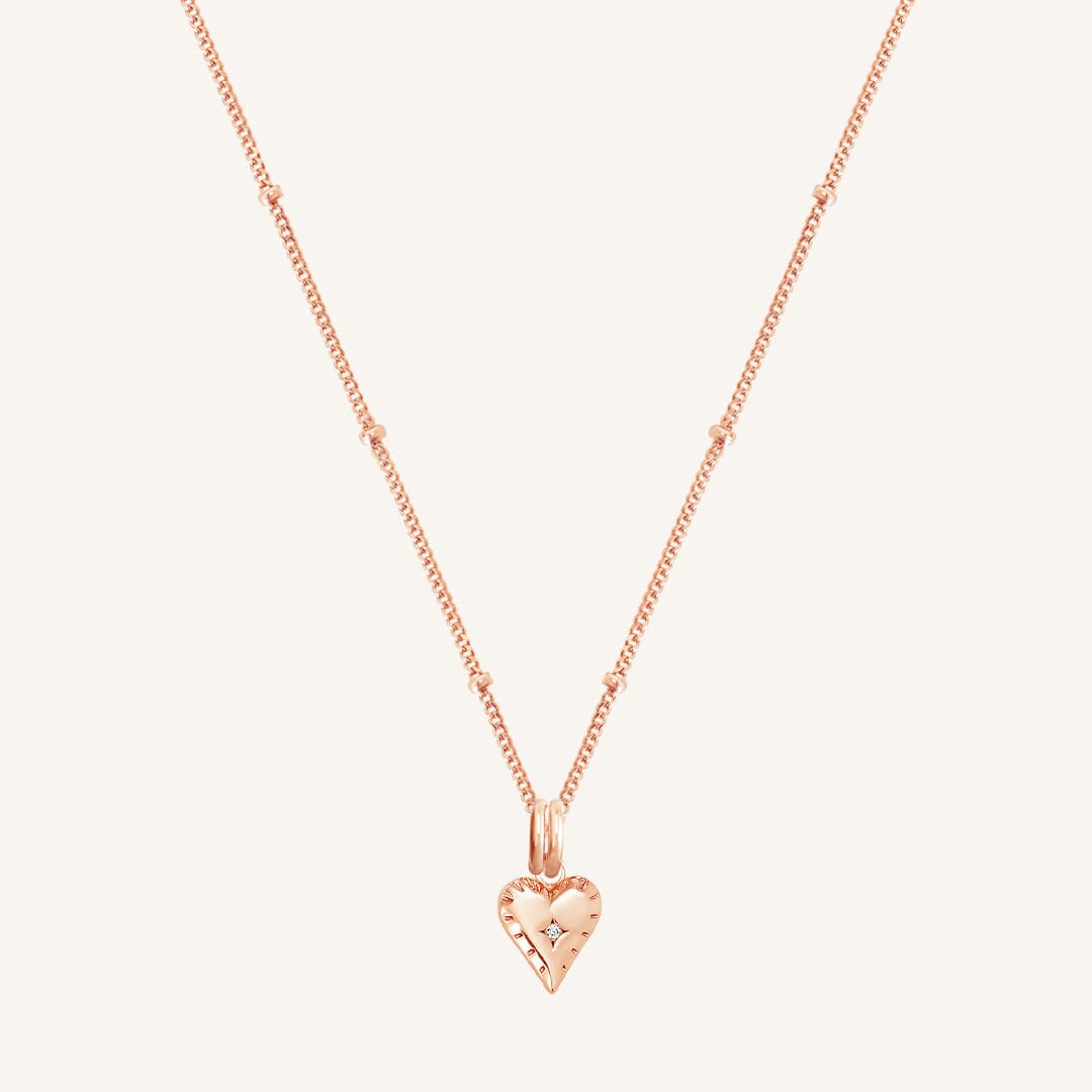 A gold-tone heart-shaped charm necklace with an adjustable chain.