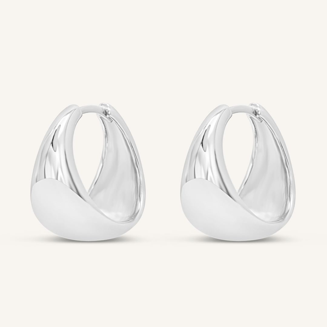 A pair of silver chunky hoop earrings on a white background.