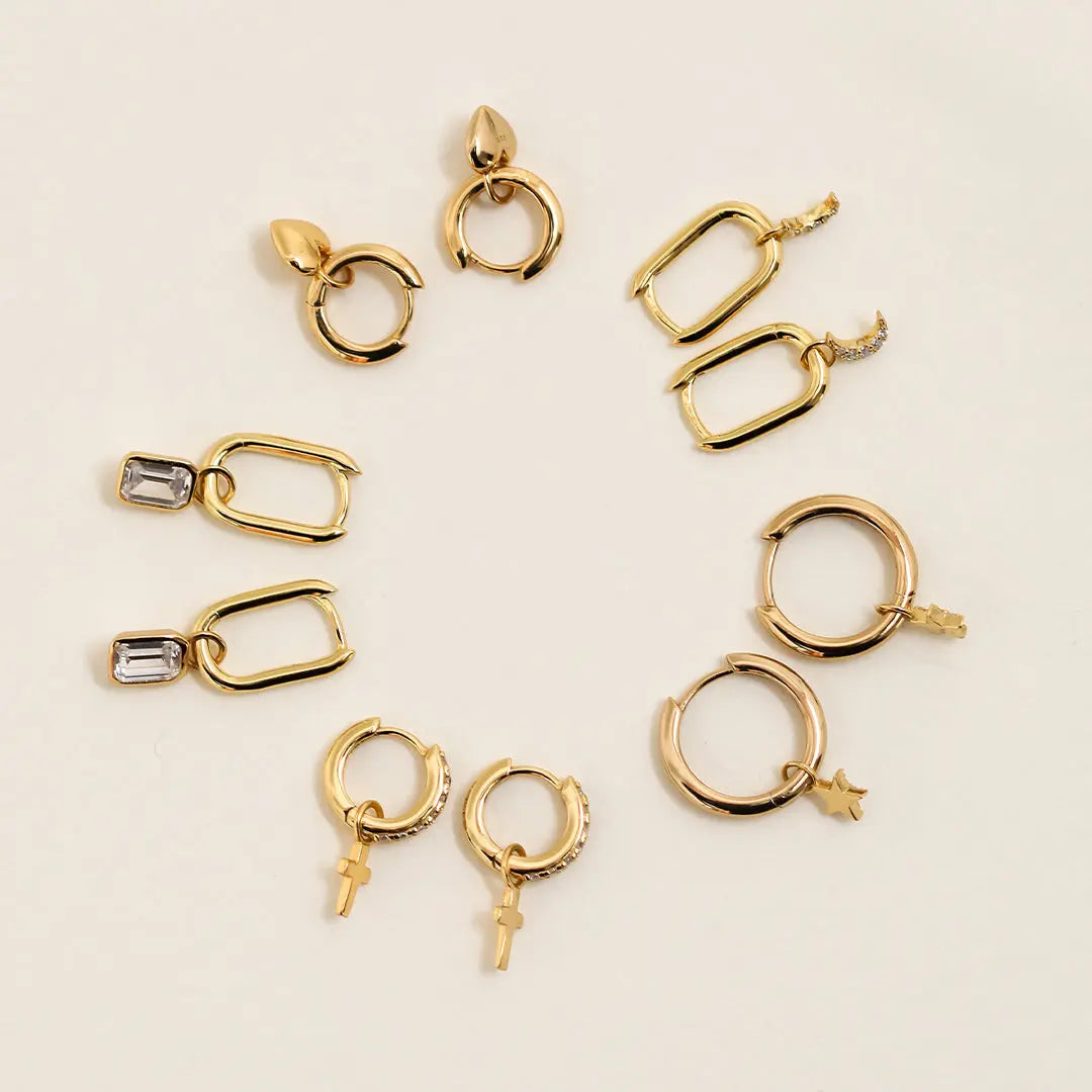 A rectangular pair of hoop charms with cubic zirconias attached to hoops, with other hoops