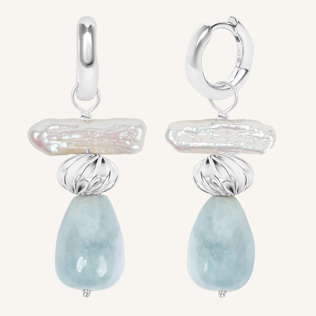 Pair of earrings with silver and gemstone designs on a white background