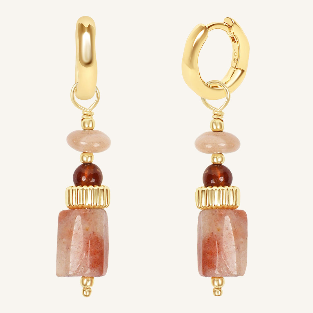 Gold hoop earrings with stone beads on a white background