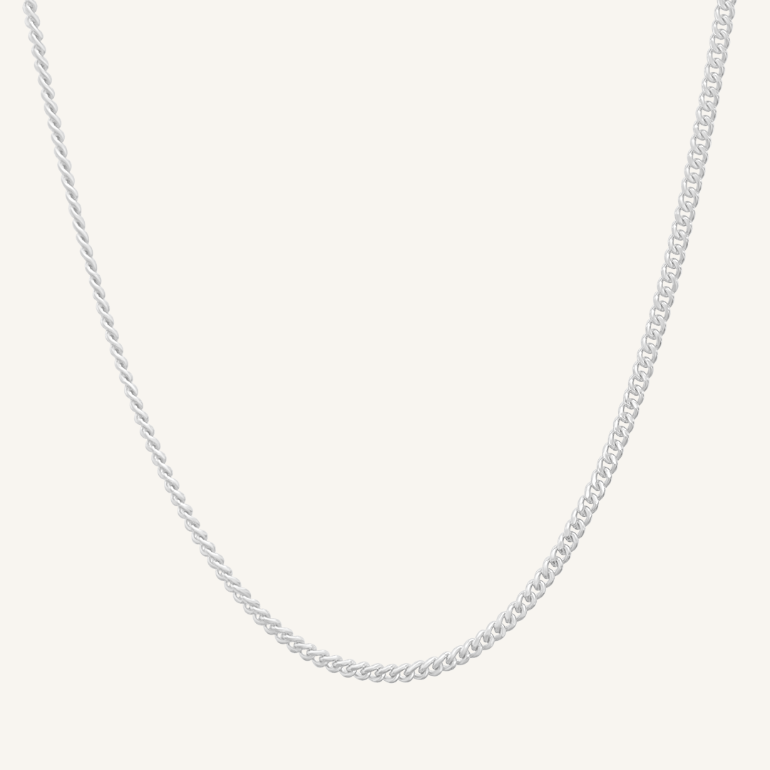 Silver chain necklace on a light gray background