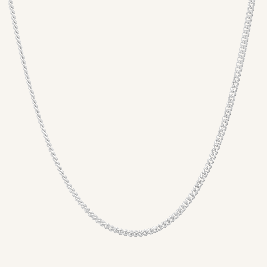 Silver chain necklace on a light gray background