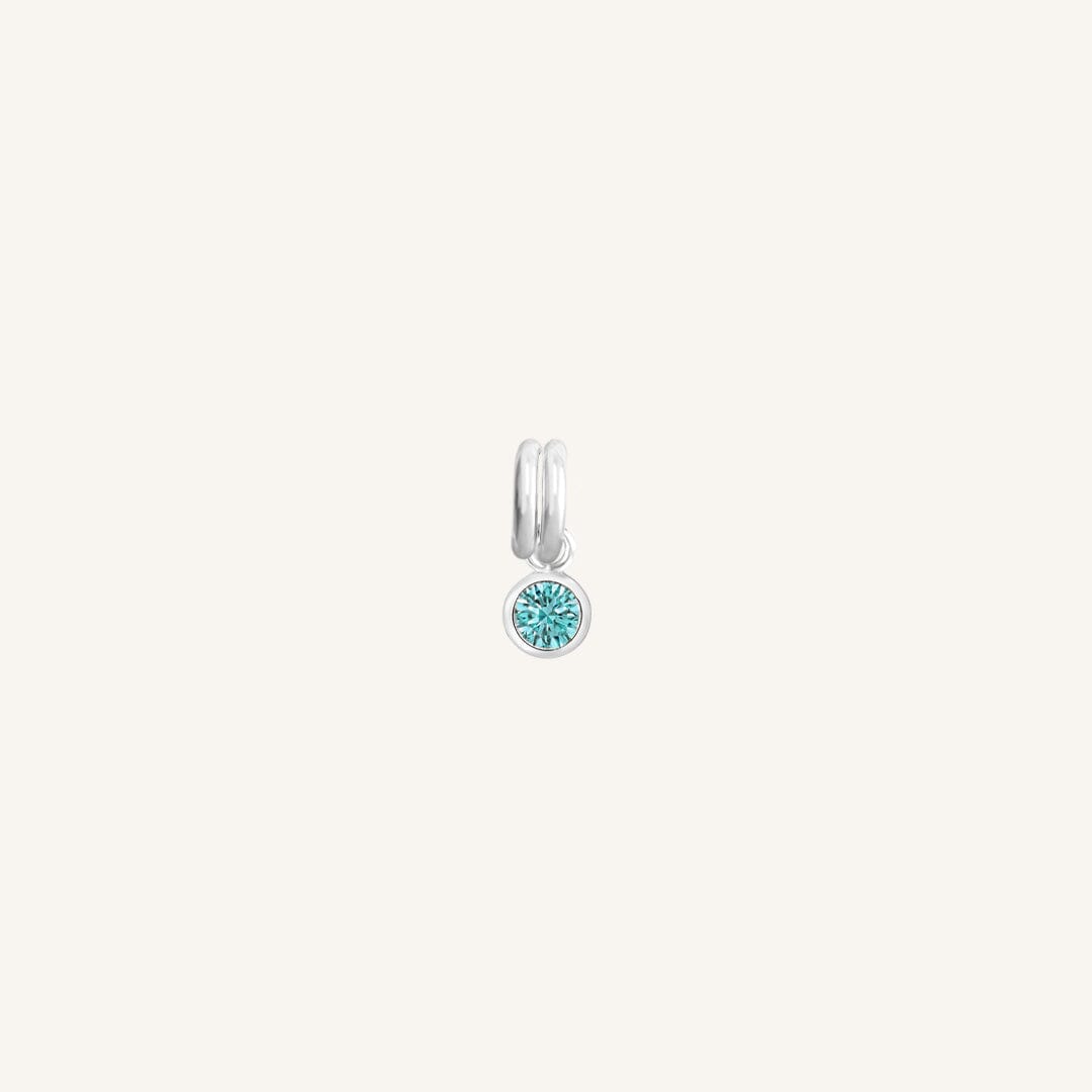 Round silver charm with bezel-set turquoise cubic zirconia representing the December birthstone