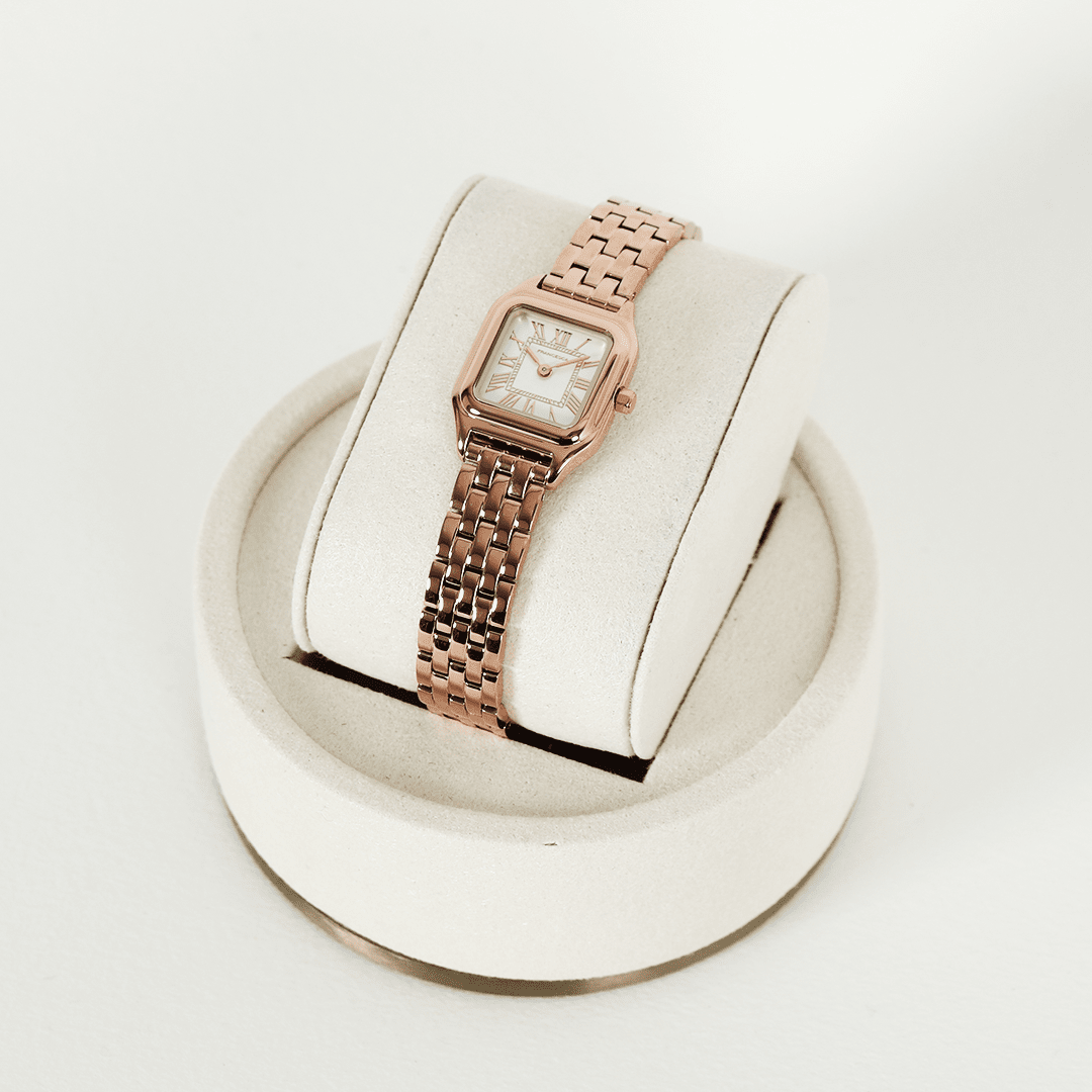 A rose gold-toned Louis Watch with a link bracelet and a square face featuring Roman numerals.