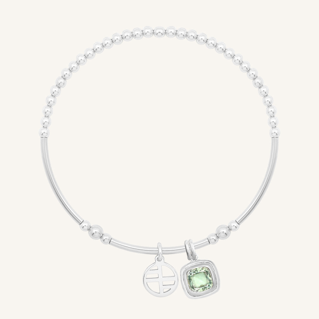 Silver bracelet with a green gemstone on a white background