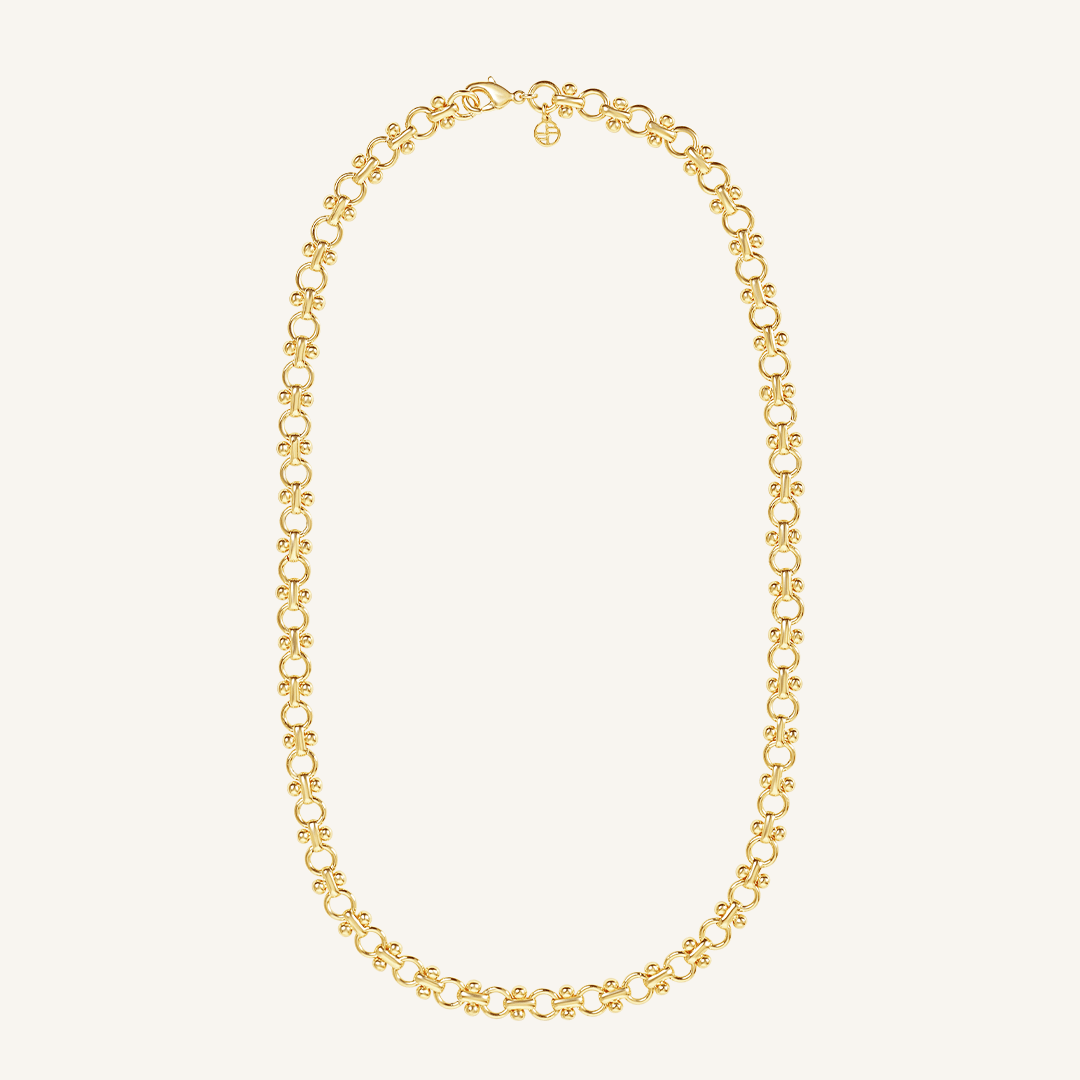 gold chain necklace inspired by Eiffel tower on plain background
