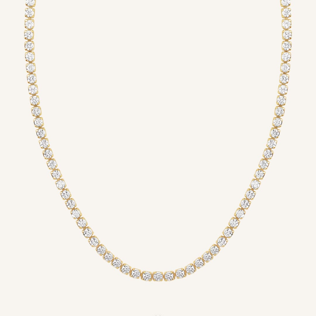 A tennis chain necklace with gold metal tone.