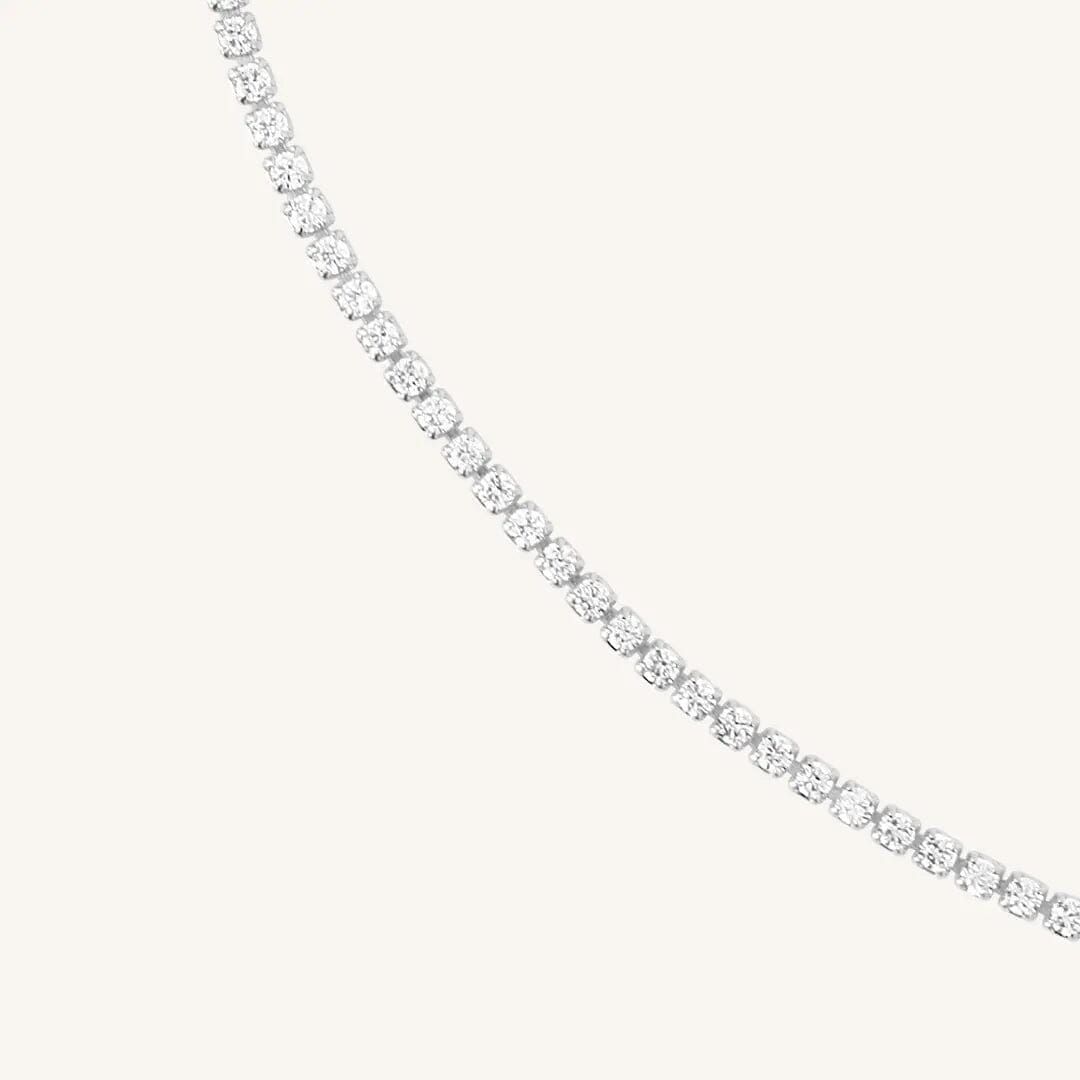 Close up of tennis chain necklace with silver metal tone.