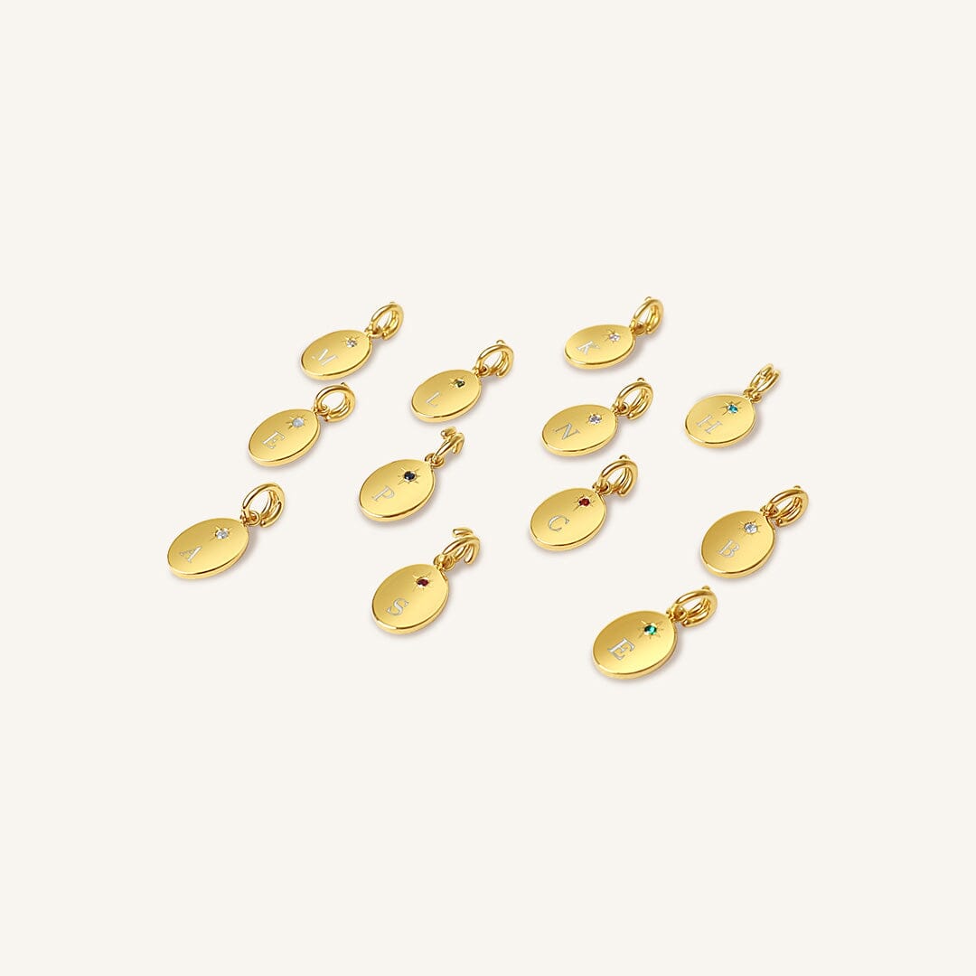 Gold pendants with embedded gemstones on a white background