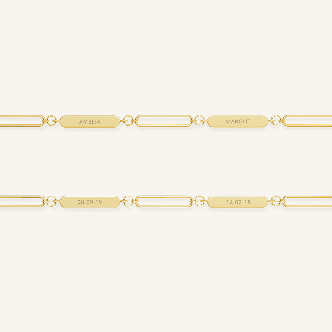 A gold chain necklace with two engraveable panels on a white background