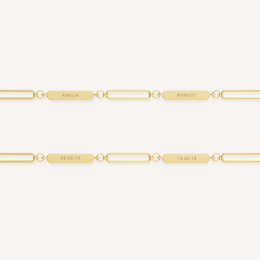 A gold chain necklace with two engraveable panels on a white background