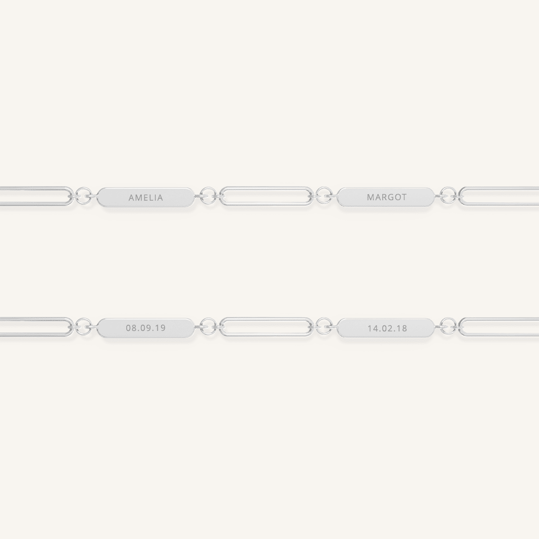 A silver chain necklace with two engraveable panels on a white background