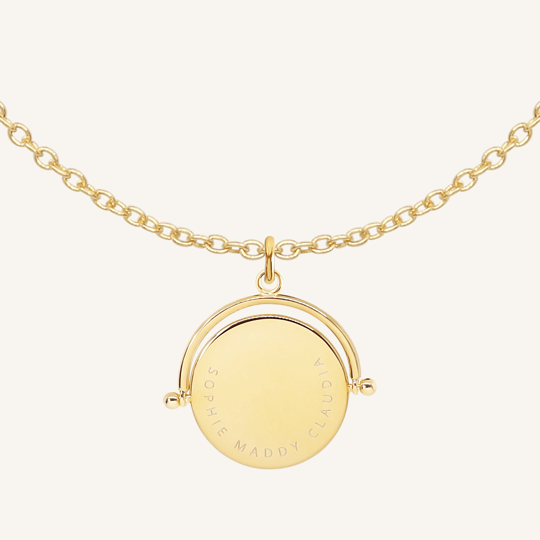 A gold-coloured, engraved pendant with, featuring a spinning mechanism, on chain