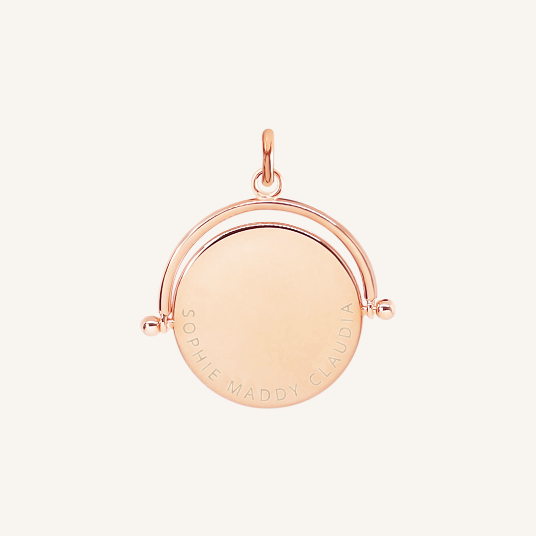 A gold-coloured, engraved pendant with, featuring a spinning mechanism.