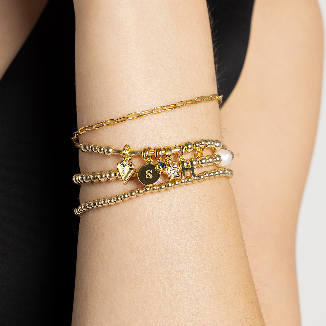 Gold bracelets stacked on wrist