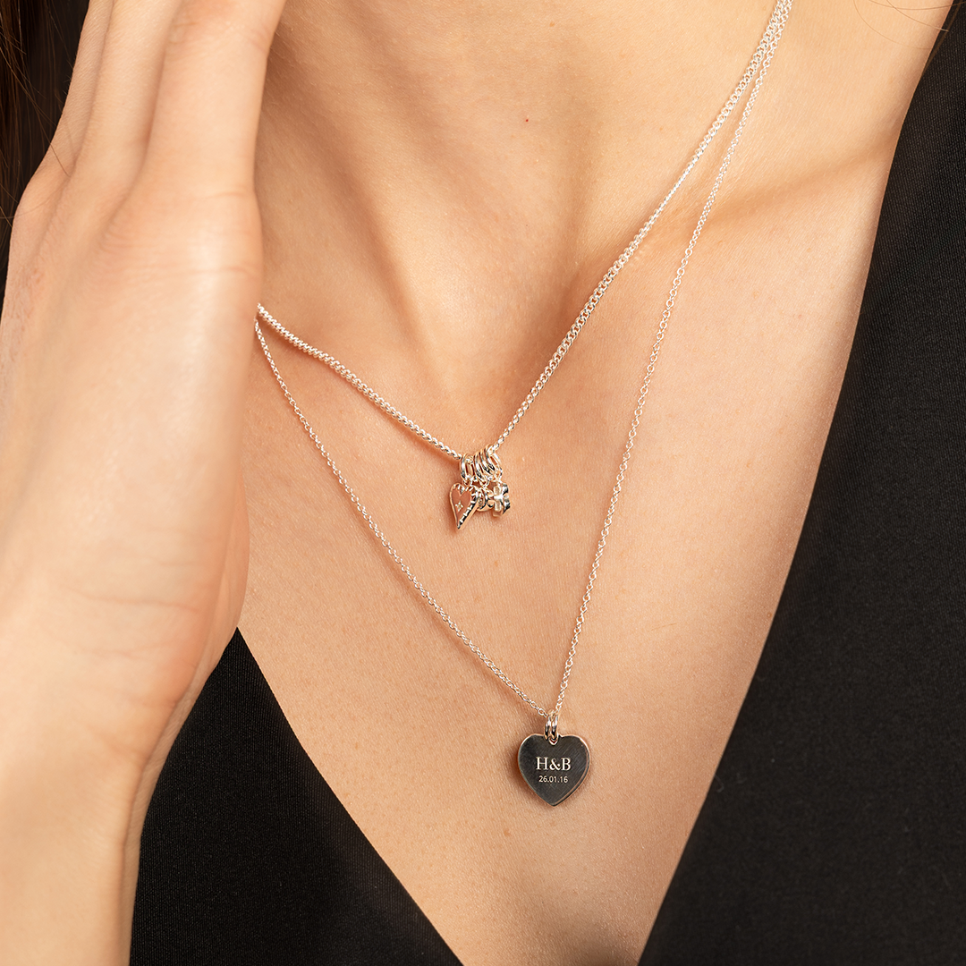 A silver-tone heart charm necklace with a fine chain around neck