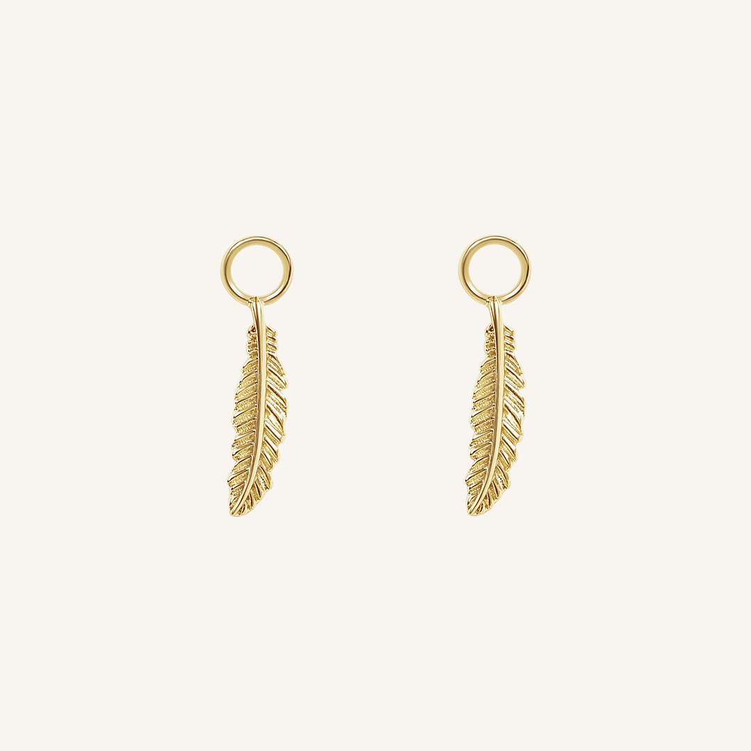 A set of two gold hoop charms with a feather design, on white background