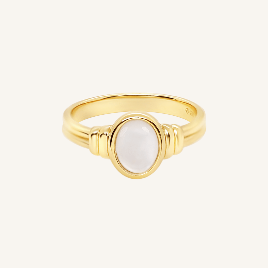 Gold ring with a Mother of Pearl stone on a white background