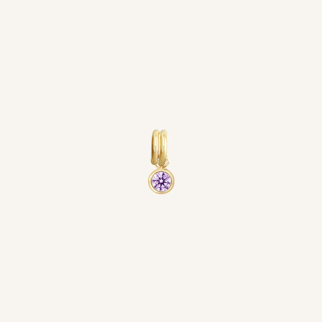 Round gold charm with bezel-set amethyst cubic zirconia representing the February birthstone.