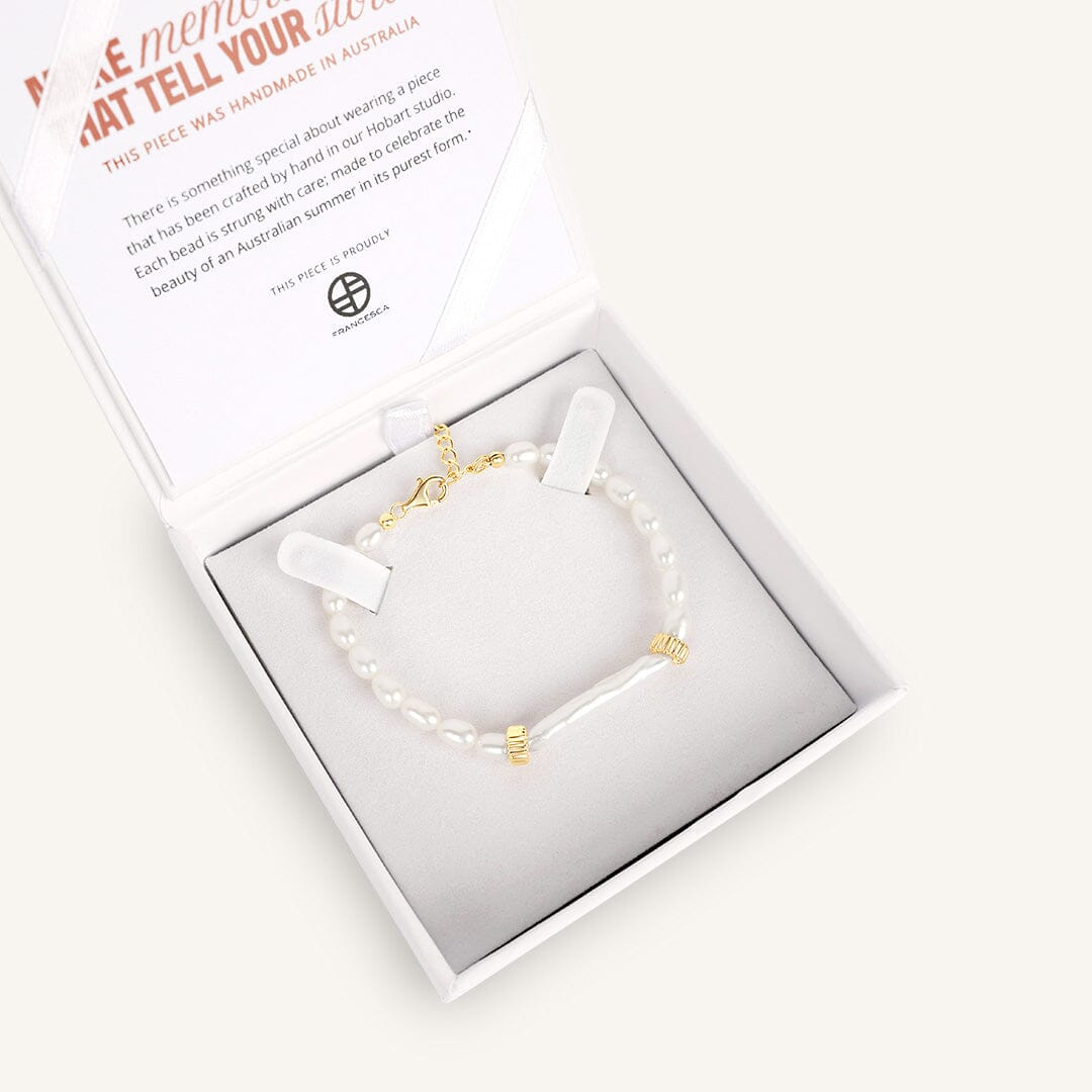 Bracelet with gold accents in a white box on a light background