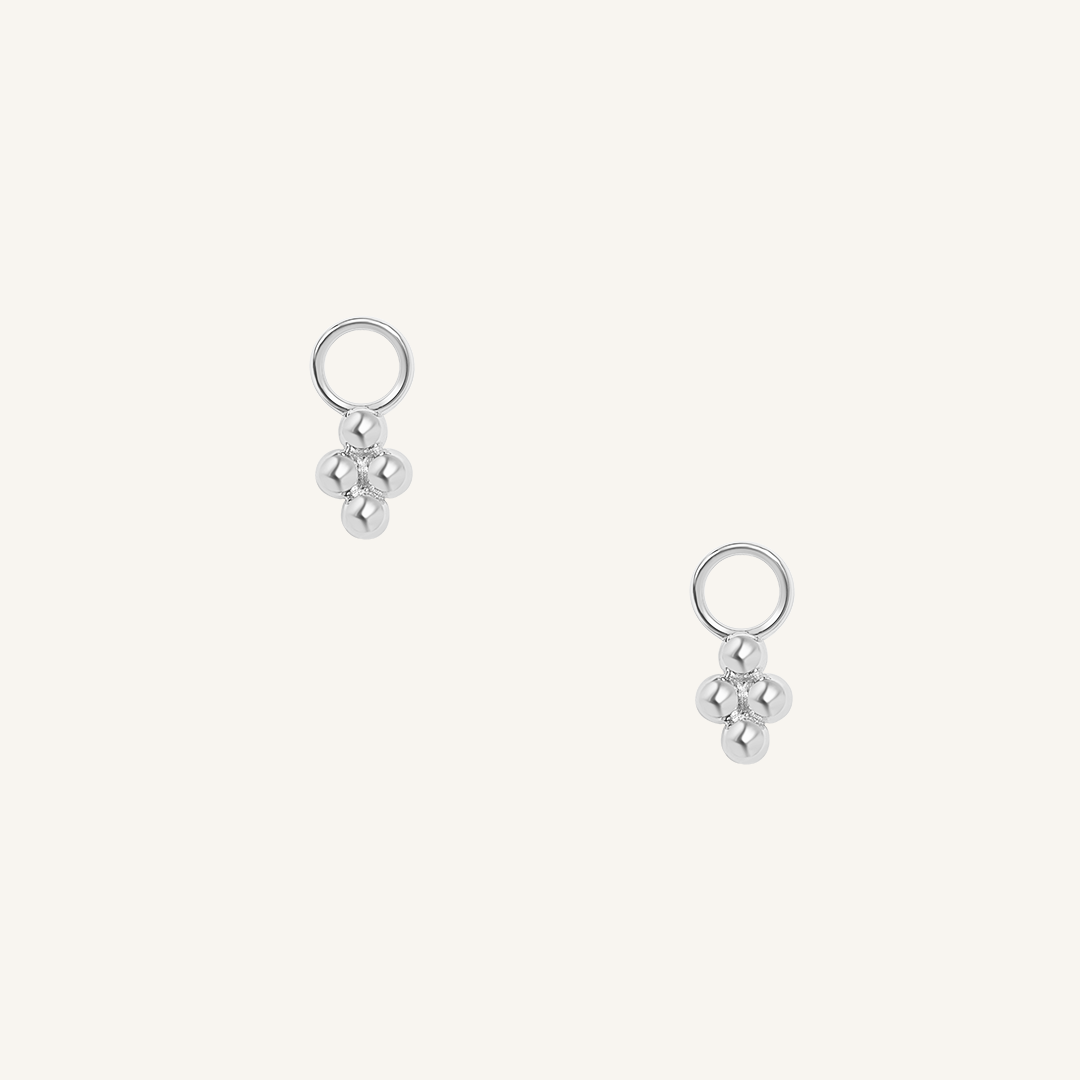 A set of two hoop charm earrings, featuring petite bobble details.